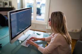 woman doing remote working at home using her keyboard to type on the computer